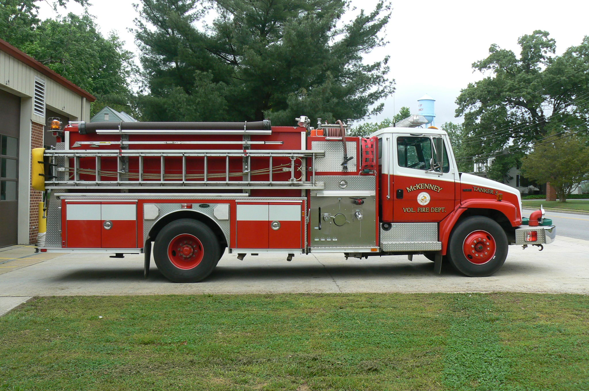Red fire tanker truck with ladder